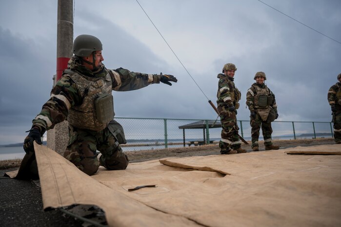 U.S. Air Force Senior Airman Nathanial Titus, 35th Fighter Wing Mission Ready Airman (MRA) program participant, instructs other participants on folding a tent cover during spoke teardown as part of the Beverly Sunrise 25-03 exercise at Misawa Air Base, Japan, March 18, 2025.