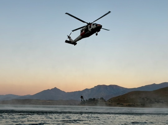 HM1 Brian Romero, a native of Gilbert, Arizona, rappels from a helicopter as an SMT with VX-31, known as the “Dust Devils,” based at NAWS China Lake. Romero serves as the sole medical provider and air crewman aboard the aircraft, delivering critical care in extreme conditions. Stationed at NMRTU China Lake, he also leads the Aviation Medicine department, ensuring aviator readiness and mentoring junior Sailors, while supporting VX-31’s 24/7/365 SAR operations across a vast AOR, including bases ranging from NAS North Island all the way to Nellis AFB, as well as civilian rescues in Kern, Mono, Tulare, and Inyo counties and National Parks. His role blends high-angle rescue expertise with paramedic skills, embodying the demanding and fulfilling life of an SMT (Photo Courtesy of U.S. Navy).