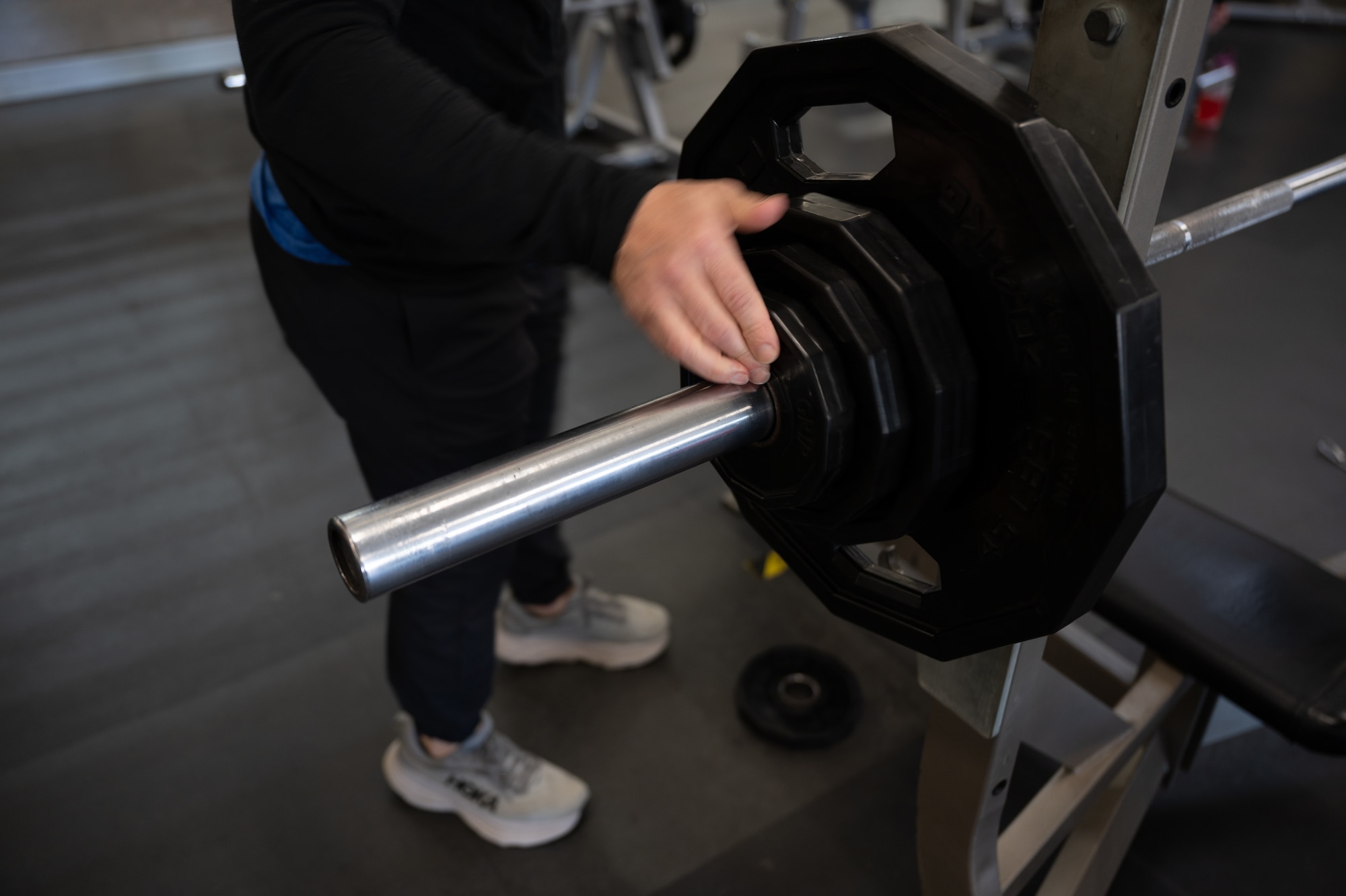 Man puts weight plate on barbell. (U.S. Air Force Photo by Airman 1st Class Donnell Ramsey)