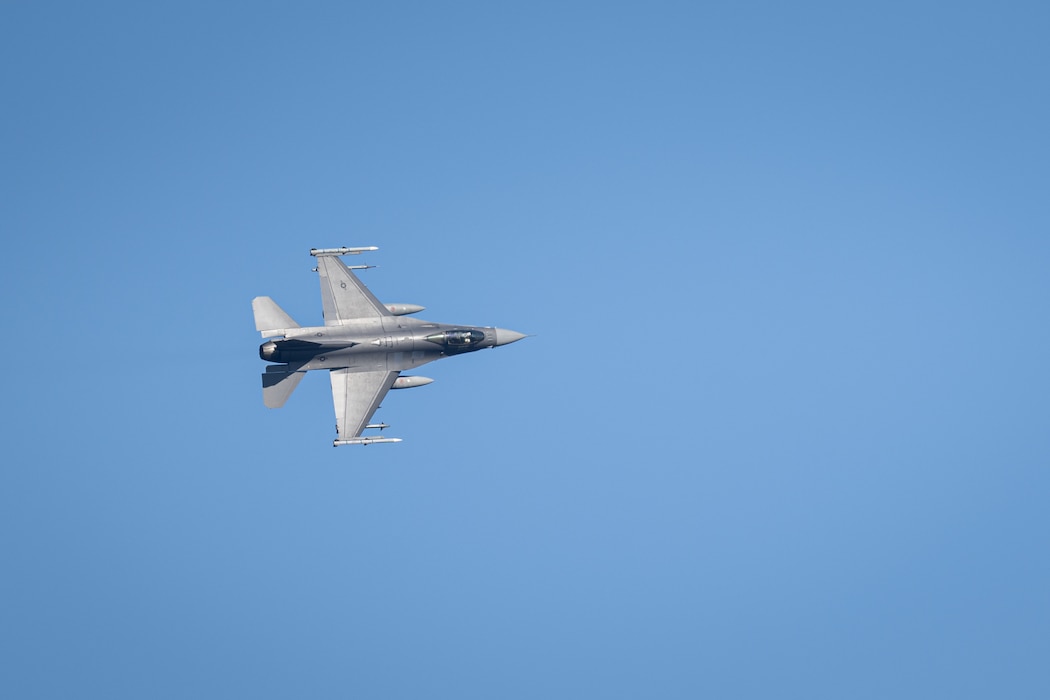 An F-16 Fighting Falcon turns in the sky as it prepares to land.