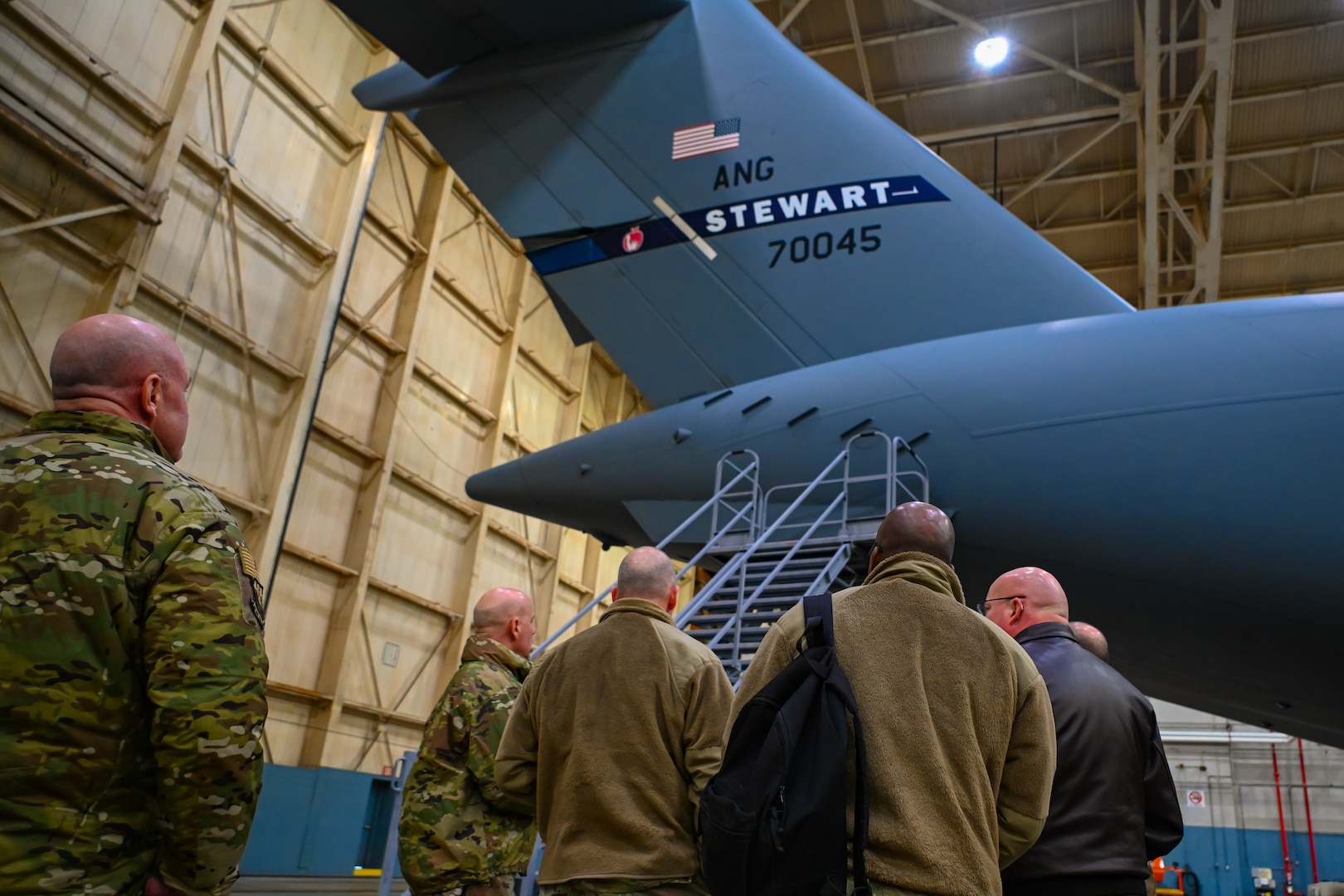 New York Air National Guard leaders look at a C-17 Globemaster III equipped with microvanes at Stewart Air National Guard Base, New York, Feb. 2, 2025. Microvanes are 3D printed devices that reduce drag and fuel consumption by 1%, saving the Air Force money and enhancing mission capability.