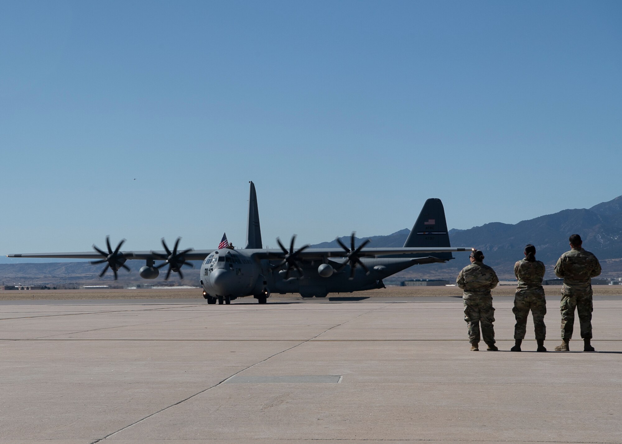 Two aircraft being observed by three servicemembers.