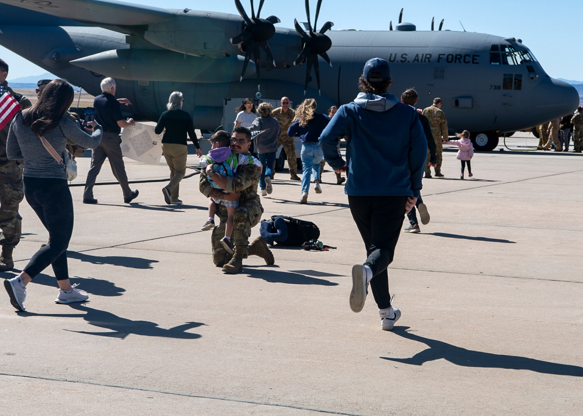 Families reuniting in front of a military aircraft.