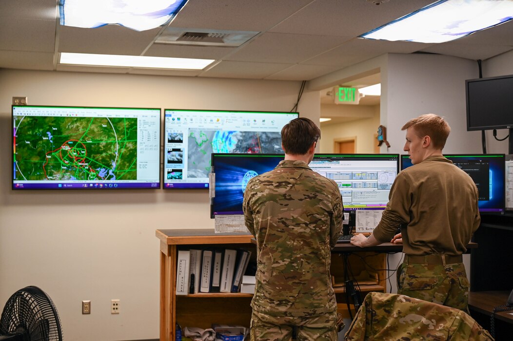 U.S. Air Force Master Sgt. Gabriel Teager, left, 354th Operations Support Squadron weather flight chief, and Senior Airman Jered Pradel, 354th OSS weather forecaster, discuss temperature and weather patterns at Eielson Air Force Base, Alaska, March 6, 2025.