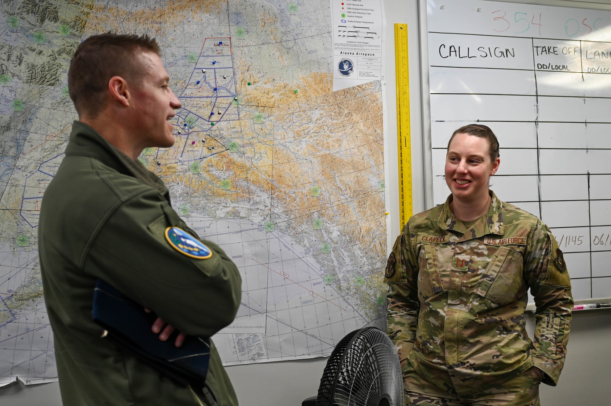 U.S Air Force Col. Curtis Dougherty, left, 354th Operations Group commander, and Capt. Erin Clapeck, 354th Operations Support Squadron weather flight commander, have a discussion about the weather flight at Eielson Air Force Base, Alaska, March 6, 2025.