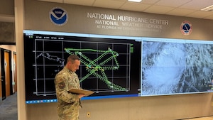 Airman gives a weather briefing at the National Hurricane Center.