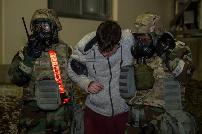 U.S. Air Force Senior Airman Zaria Berrios, left, 35th Force Support Squadron (FSS) force management technician, and Airman 1st Class Gabrielle Gray, right, 35th FSS customer support technician, carry a casualty actor during Beverly Sunrise 25-03.
