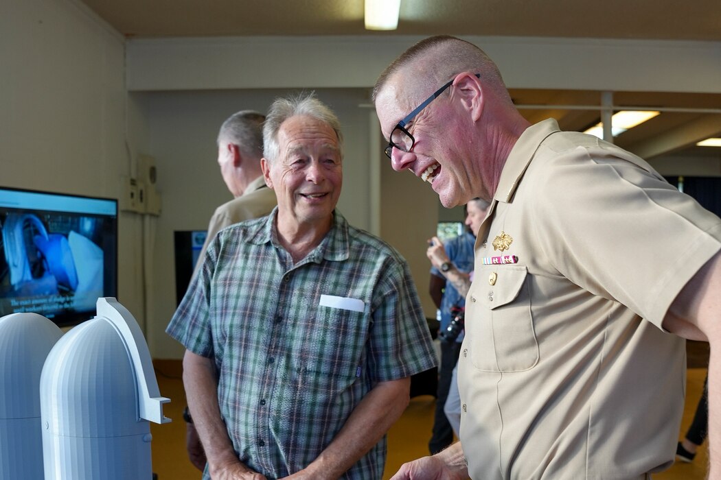 HONOLULU (March 12, 2025) Capt. Steven Stasick, facilities director, Navy Closure Task Force-Red Hill (NCTF-RH), speaks with a guest about a fuel tank size comparison model during the NCTF-RH open house at the Keʻehi Lagoon Memorial in Honolulu, March 12, 2025. NCTF-RH hosted the open house for members of the community to learn more about current and future efforts of the Red Hill Bulk Fuel Storage Facility (RHBFSF) closure, tank cleaning, and drinking water monitoring.  Charged with the safe decommissioning of the facility, NCTF-RH was established by the Department of the Navy as a commitment to the community and the environment, and continues to engage with the people of Hawaii, regulatory agencies, and other stakeholders as it safely and deliberately decommissions the RHBFSF. (U.S. Navy photo by Mass Communication Specialist Seaman Krystal Diaz)
