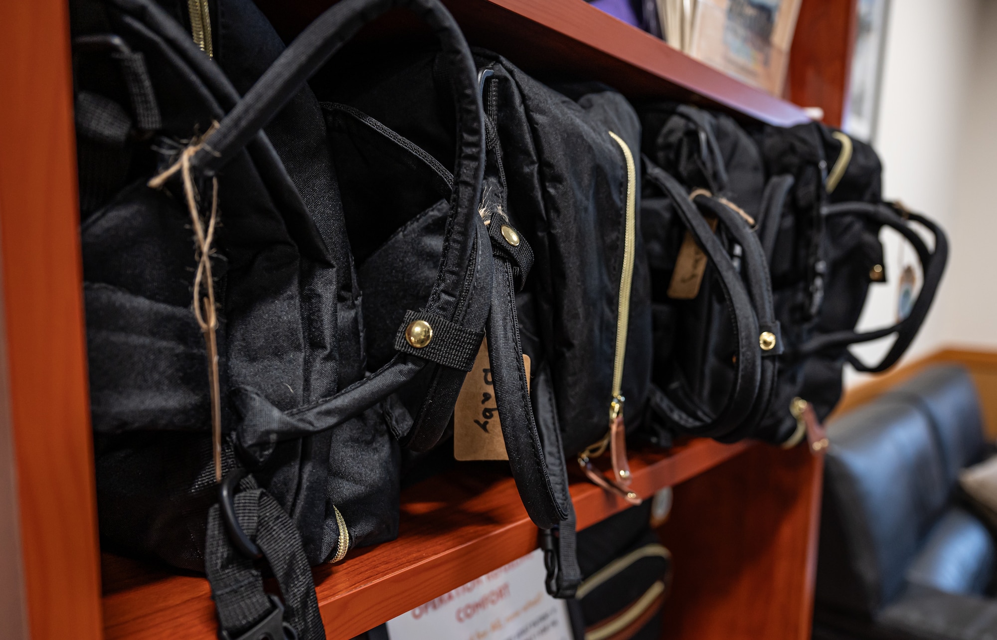 Black bags sit on a shelf.
