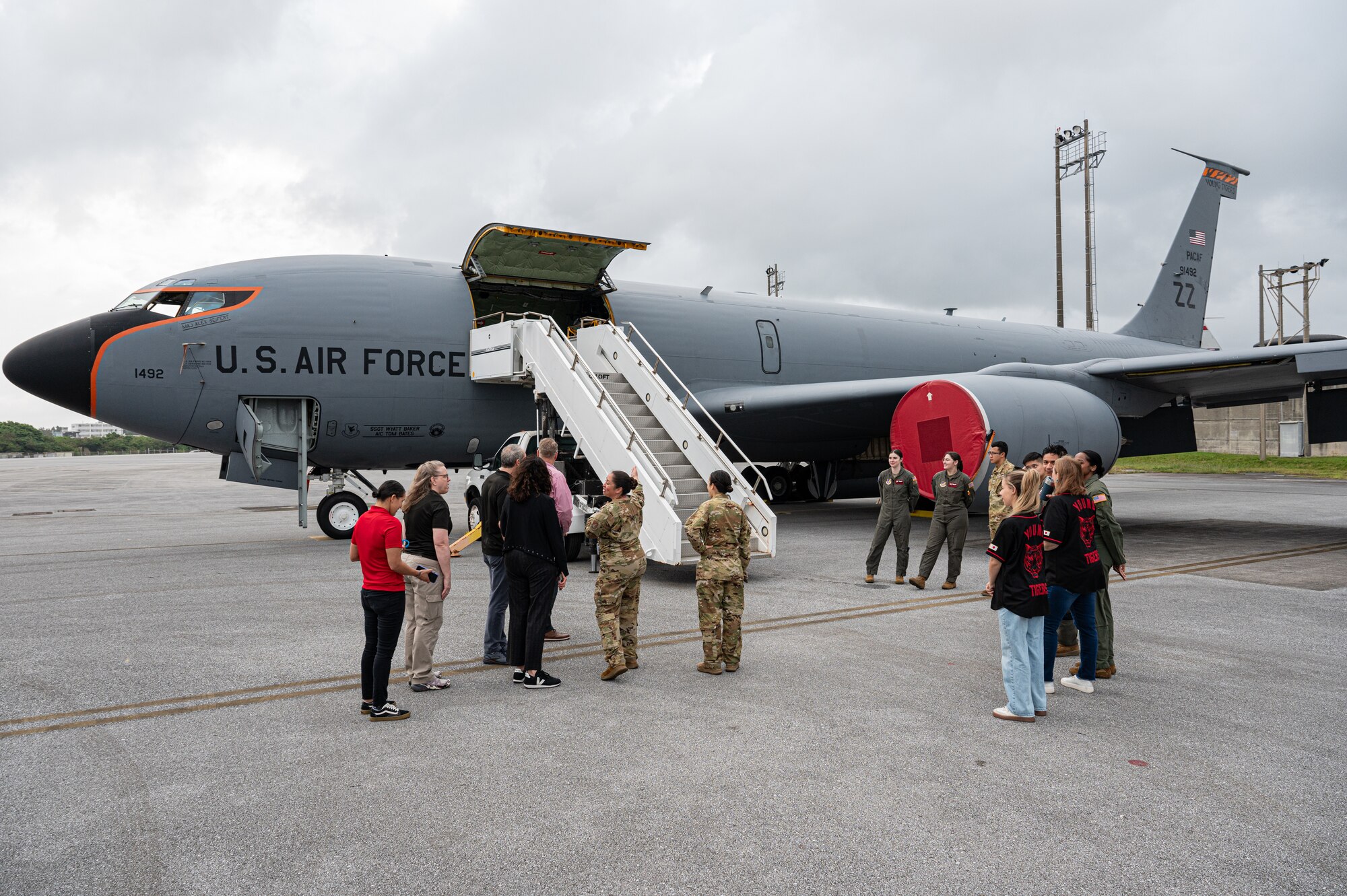 People stand outside next to a KC-135 Stratotanker.