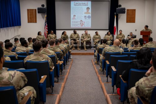 Military members sit in a room for a seminar.