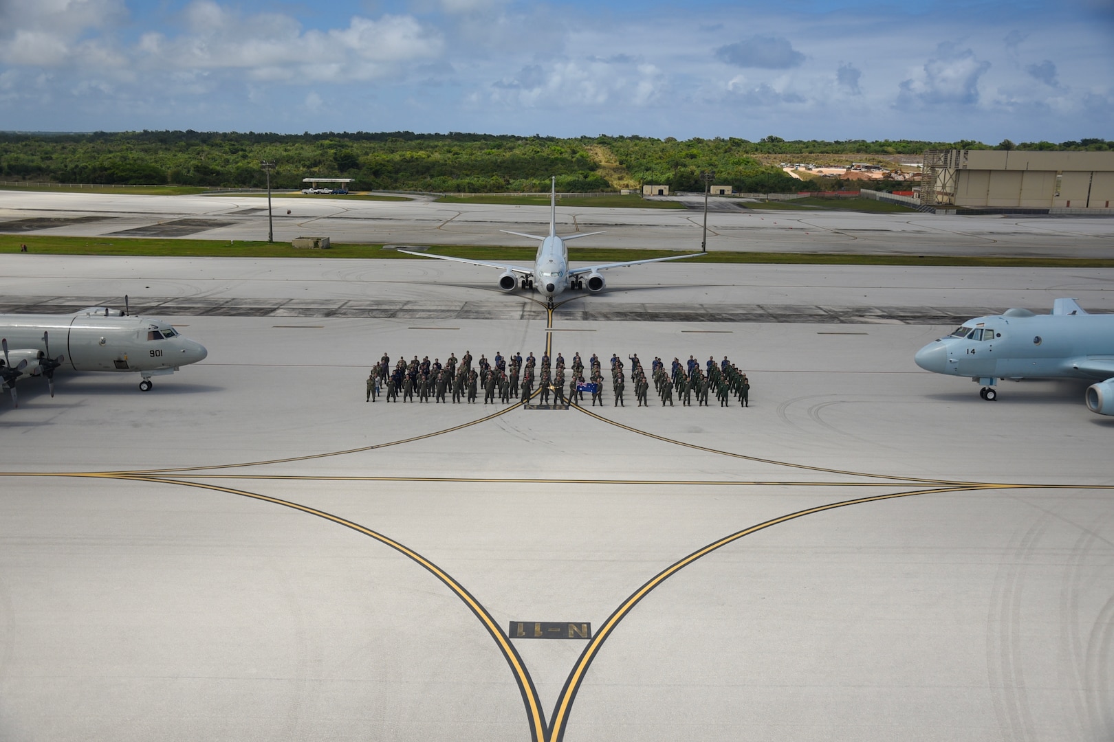 ANDERSEN AIR FORCE BASE, Guam (March 13, 2025) Participants from the Royal Australian Air Force (RAAF), Indian Navy, Japan Maritime Self-Defense Force(JMSDF), Republic of Korea Navy(ROKN), and the United States Navy pose for a group photo alongside a ROKN P-3 Orion (left), RAAF P-8A Poseidon (center), and JMSDF Kawasaki P-1 (right) during Exercise Sea Dragon 2025 at Andersen Air Force Base , Guam, March 13, 2025.