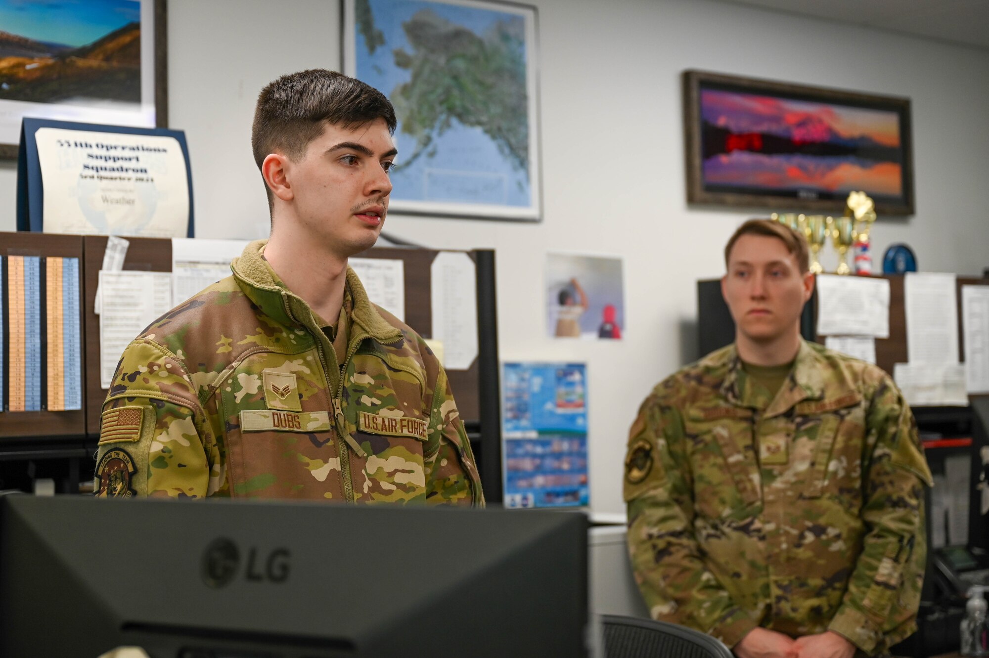 U.S. Air Force Senior Airman Brodie Dubs, 354th Operations Support Squadron weather forecaster, left, conducts a shift change brief at Eielson Air Force Base, Alaska, March 6, 2025.