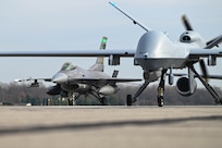 An MQ-9 Reaper assigned to the 178th Wing and an a F-16C Fighting Falcon from the 180th Fighter Wing participate in a close formation taxi "elephant walk" on Springfield-Beckley Air National Guard Base March 19, 2025.