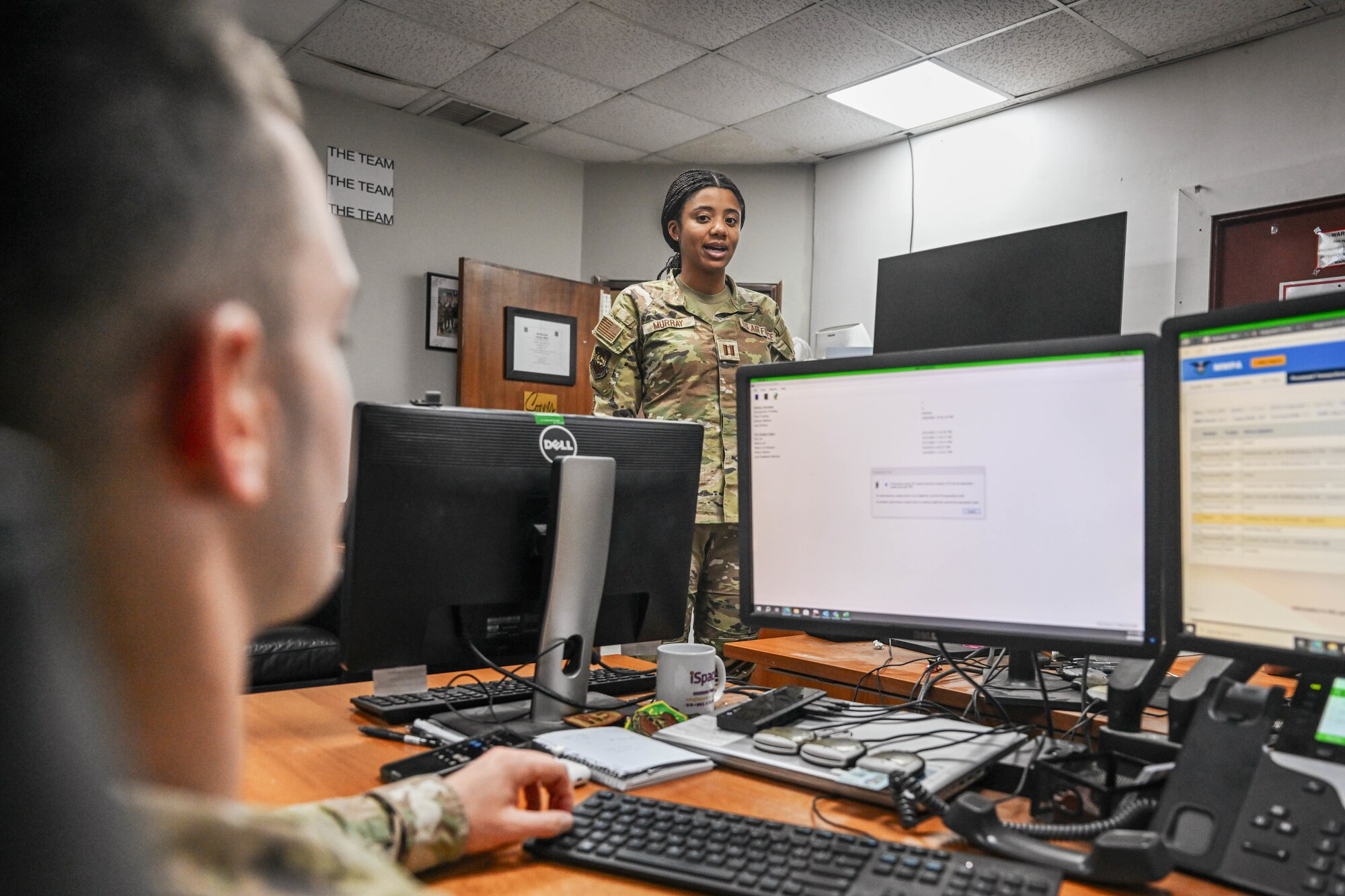 A woman in uniform speaks to a man in uniform.