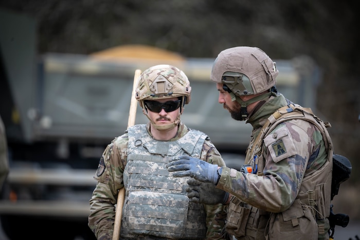 U.S. Air Force member listens to a French army member.