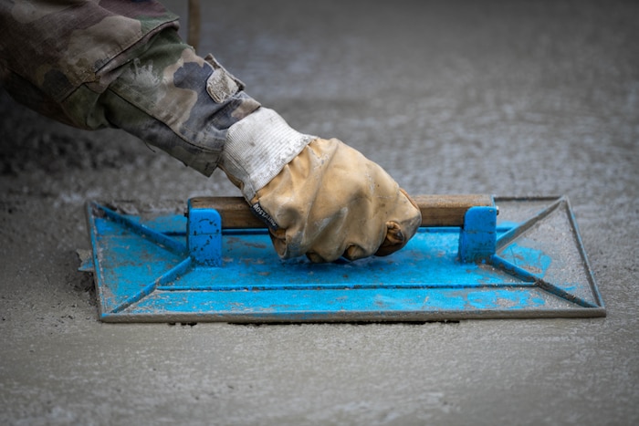 French army member smooths concrete.