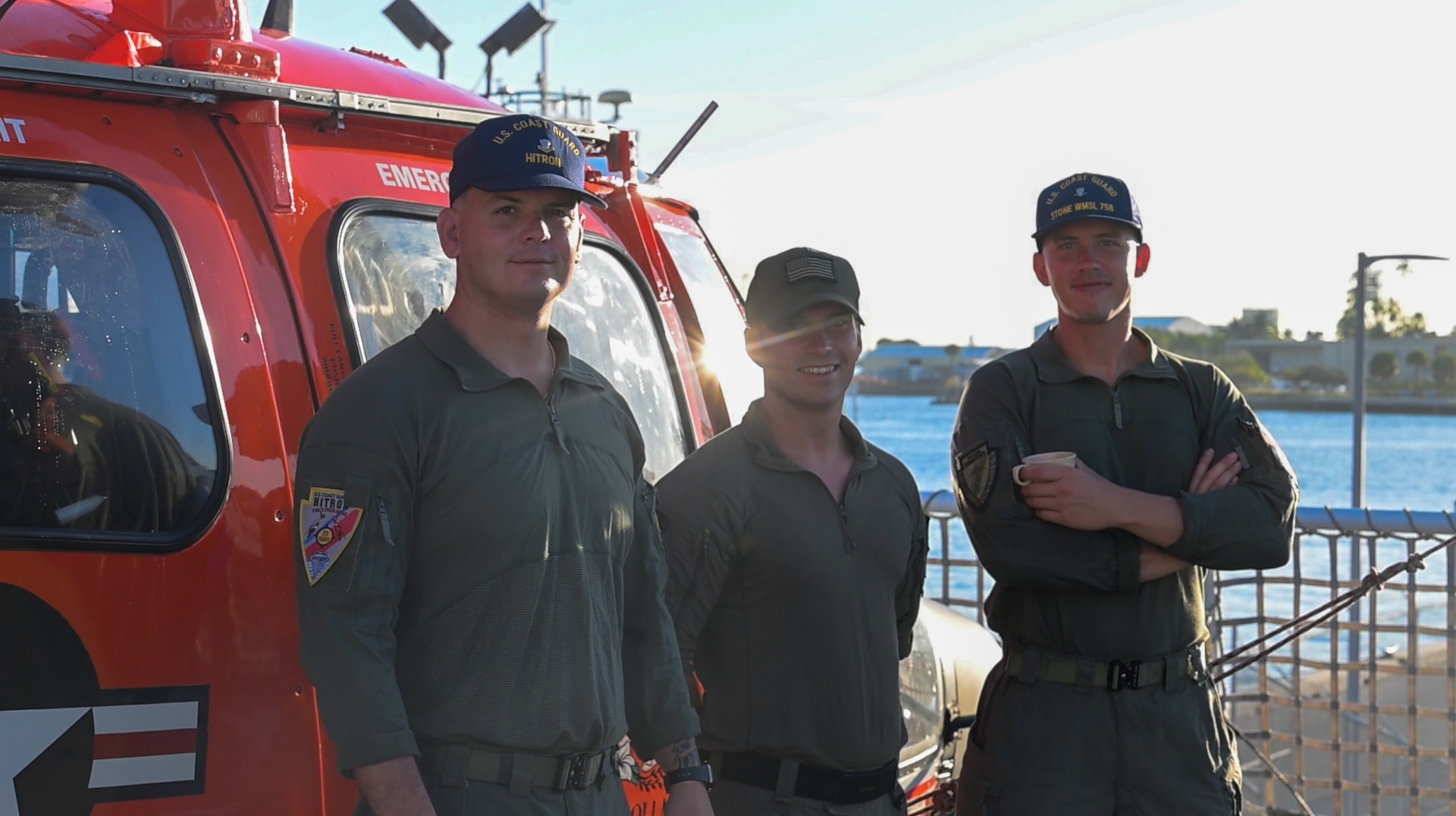 Coast Guard pilots posing by an MH-65 dolphin helicopter at Port Everglades, on March 20, 2025. The Coast Guard's Helicopter Interdiction Tactical Squadron crews frequently embark with Coast Guard Cutters on counter-narcotics patrols. (Coast Guard photo by Petty Officer 3rd Class Nicholas Strasburg)