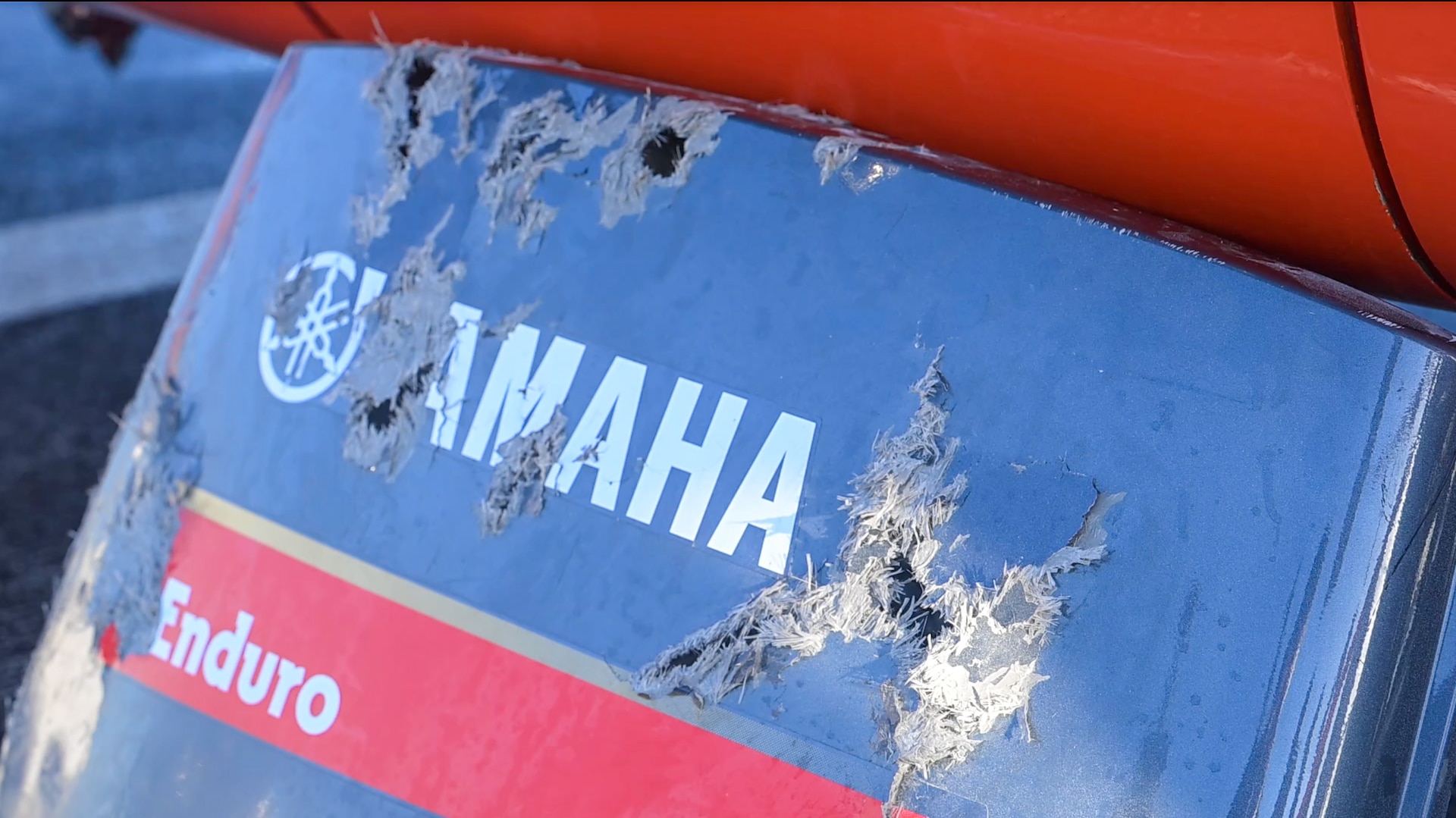 An engine cowling rests against an MH-65 dolphin helicopter at Port Everglades, on March 20, 2025. After attempts to stop a non-complaint vessel failed, the Coast Guard's Helicopter Interdiction Tactical Squadron was authorized to use force, including disabling fire. (Coast Guard photo by Petty Officer 3rd Class Nicholas Strasburg)