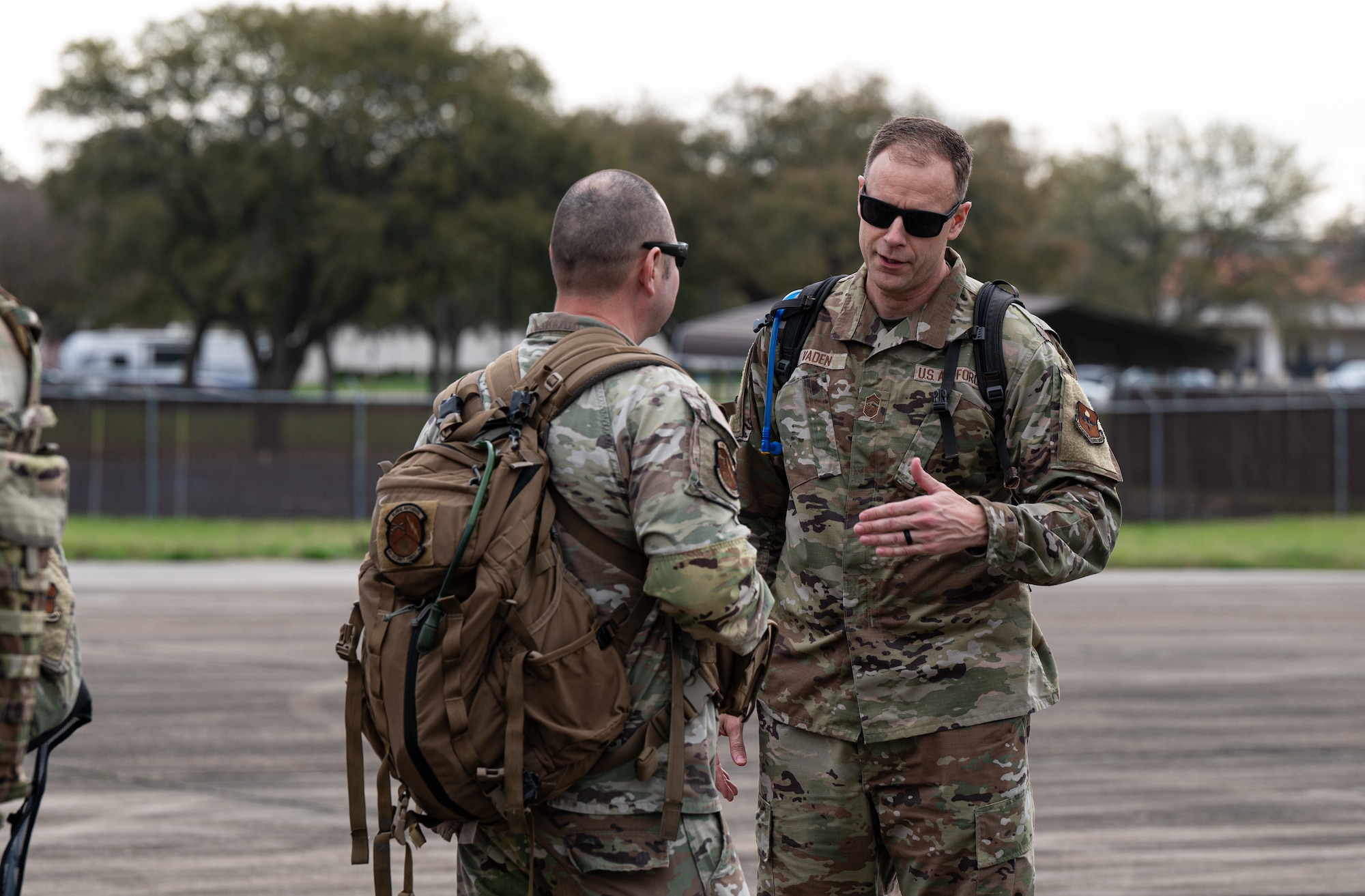 U.S. Air Force Chief Master Sgt. Caleb Vaden, right, 42nd Air Base Wing command chief, speaks with Master Sgt. Eric Godinez, 42nd Security Forces Squadron chief weapons and tactics, before Airmen taking on the Crusader Challenge depart on U.S. Army UH-60 Black Hawk helicopter at Maxwell Air Force Base, Alabama, March 14, 2025.