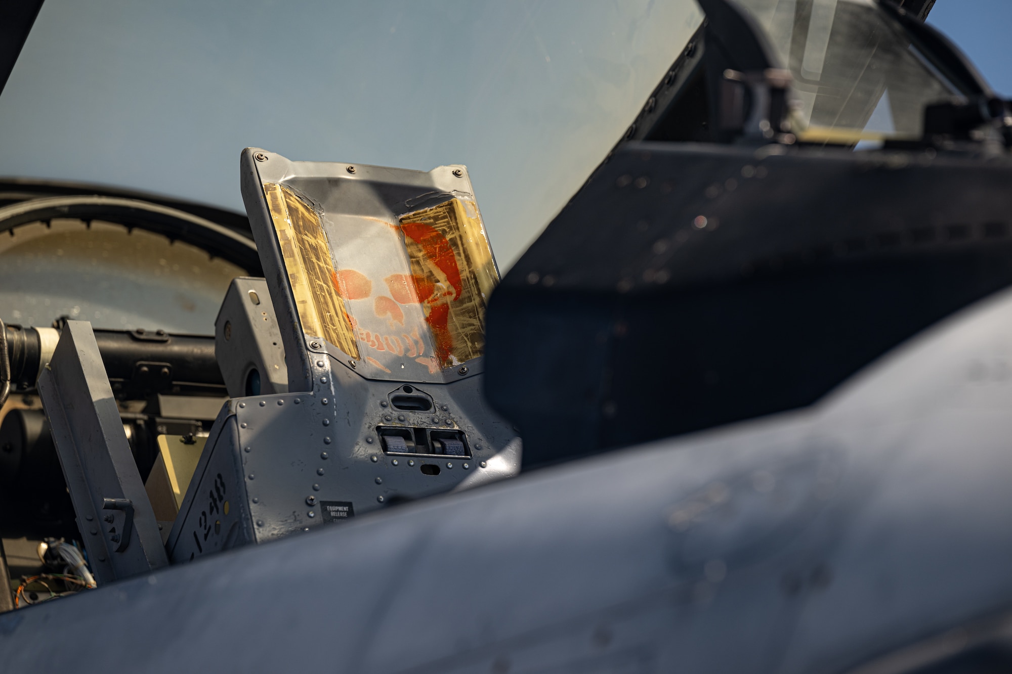 An aircraft features a head rest painted with an orange skull
