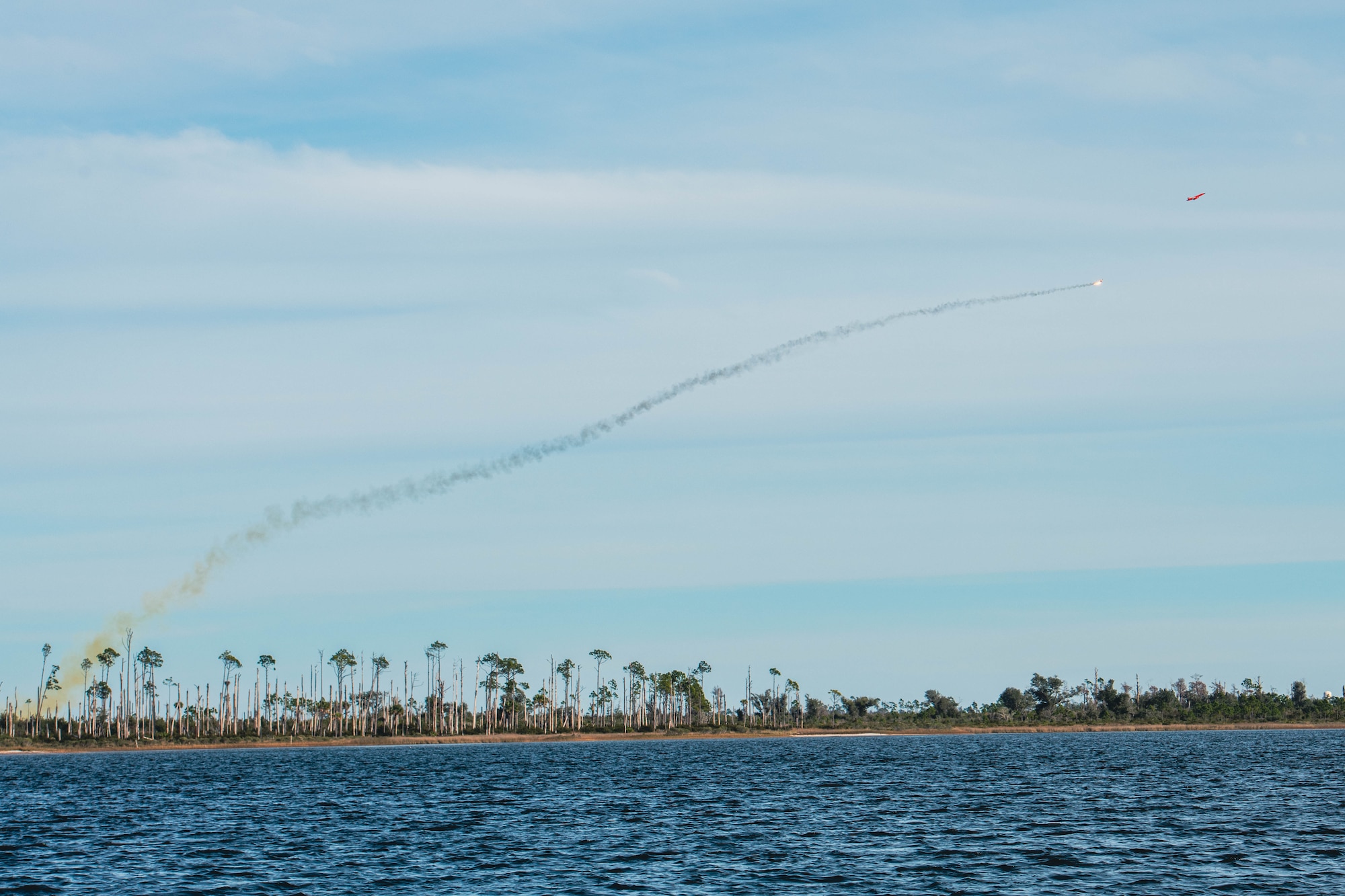 A subscale aerial target flies across the horizon