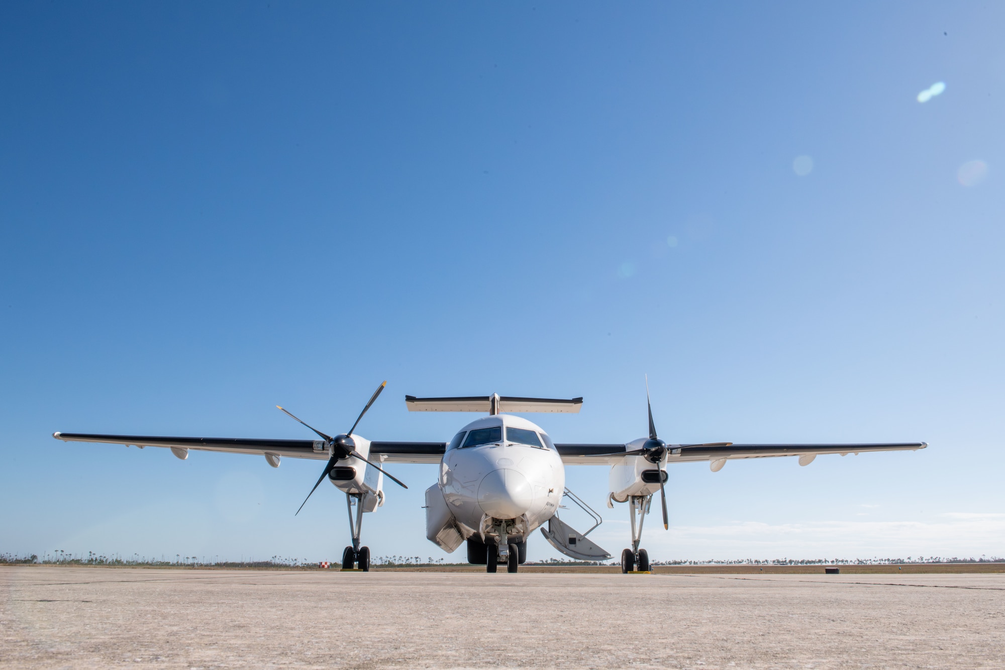 A white plane sits on the flight line.