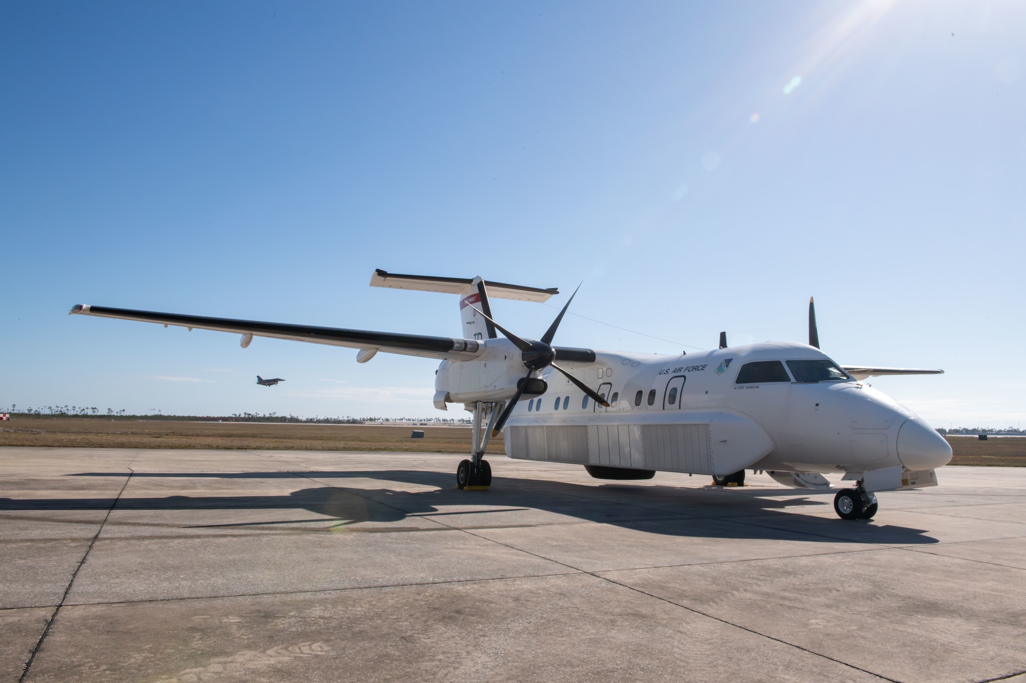 A white plane sitting on the flightline.