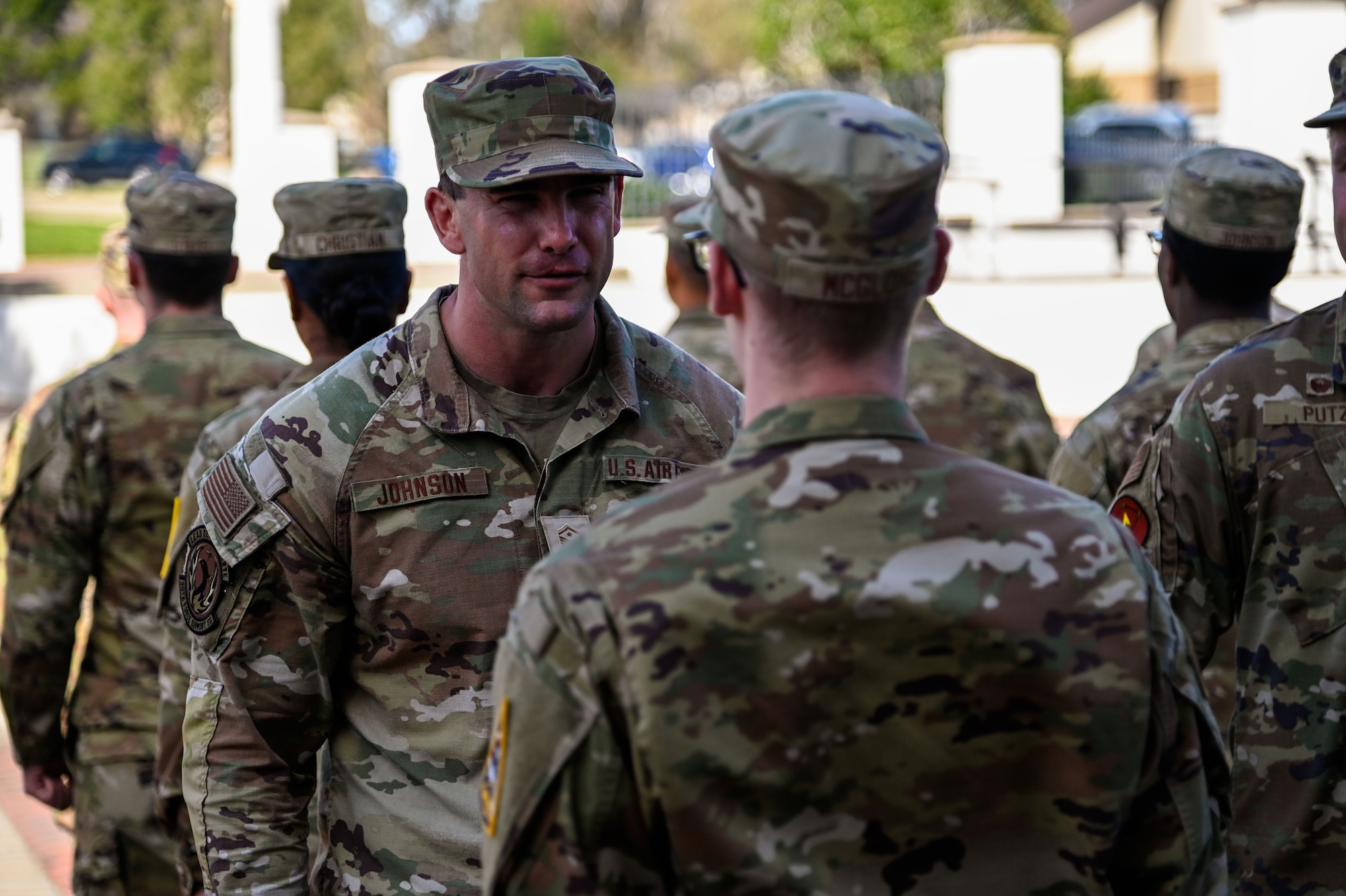 A group of people stand outside in formation.