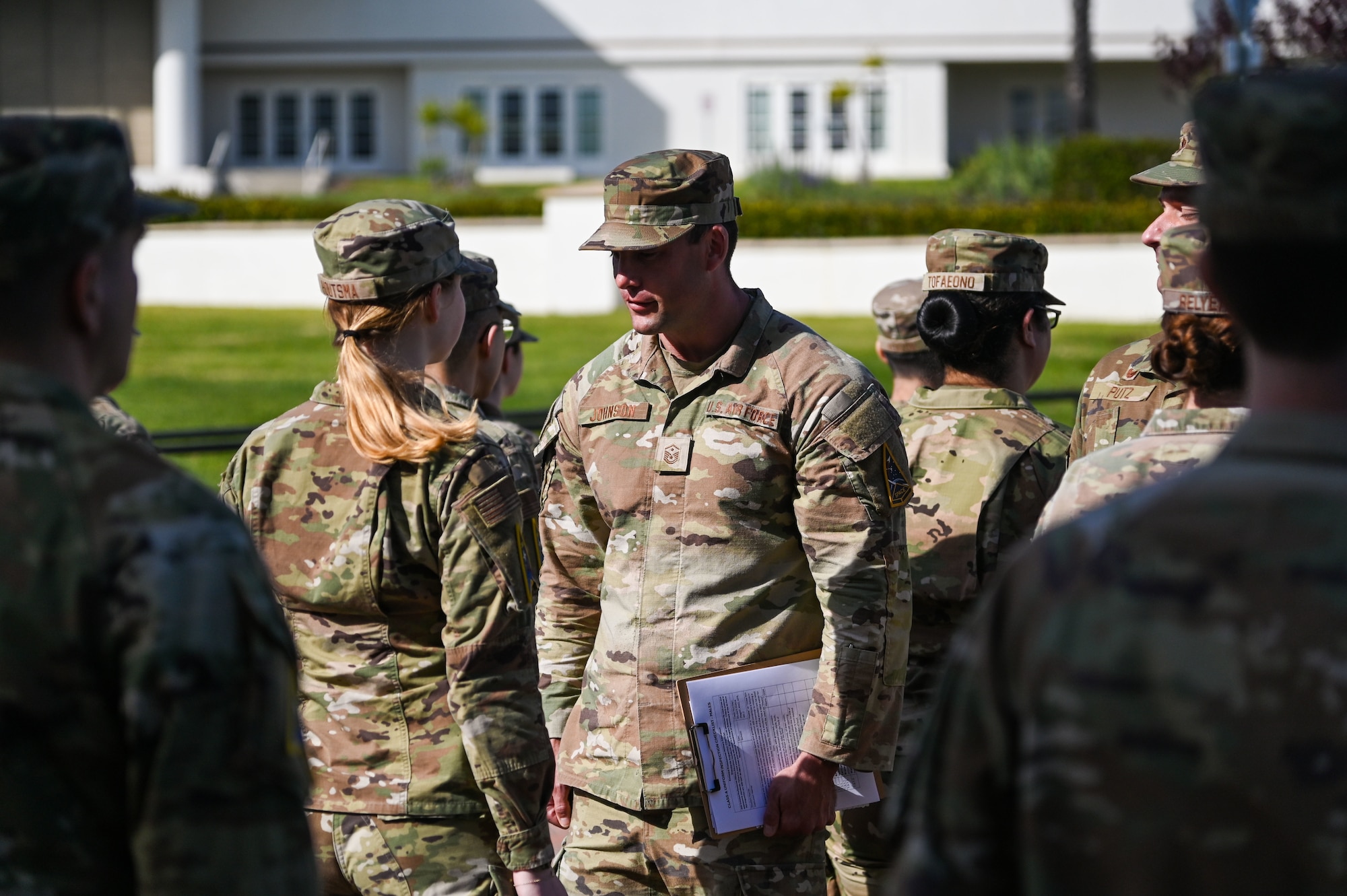 A group of people stand outside in formation.