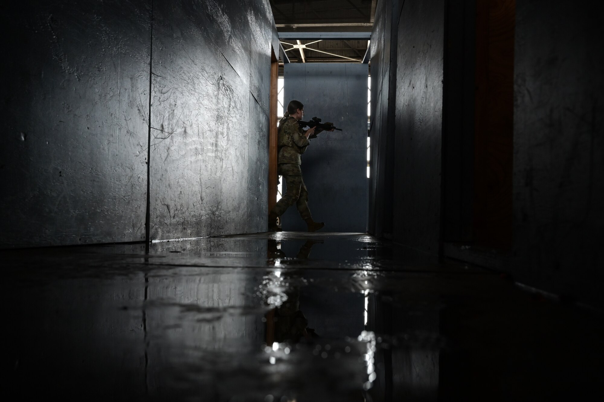 An Airman walks through a dark hallway during a close-quarter battle demonstration.