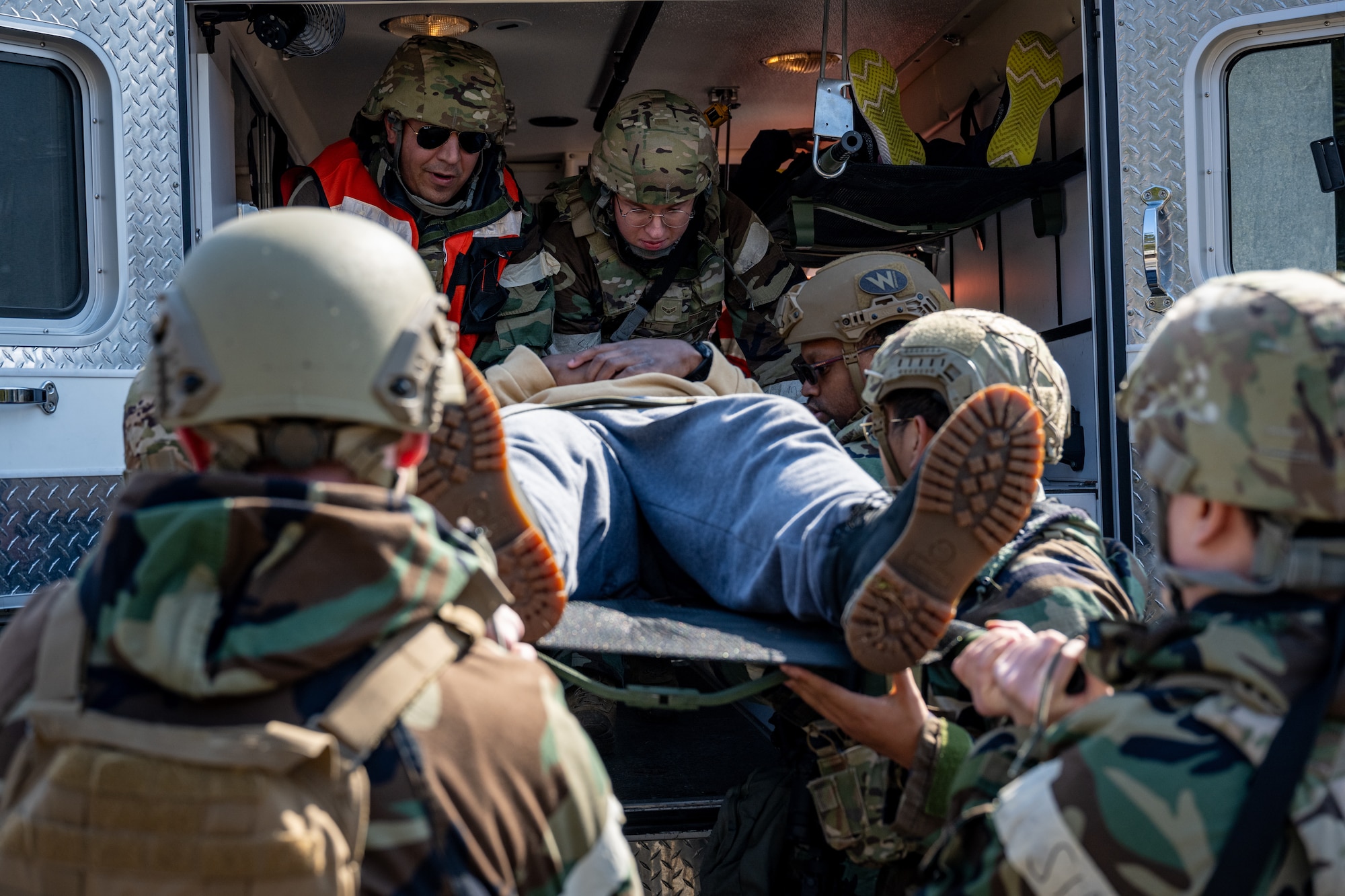 Airmen loads patient onto an ambulance