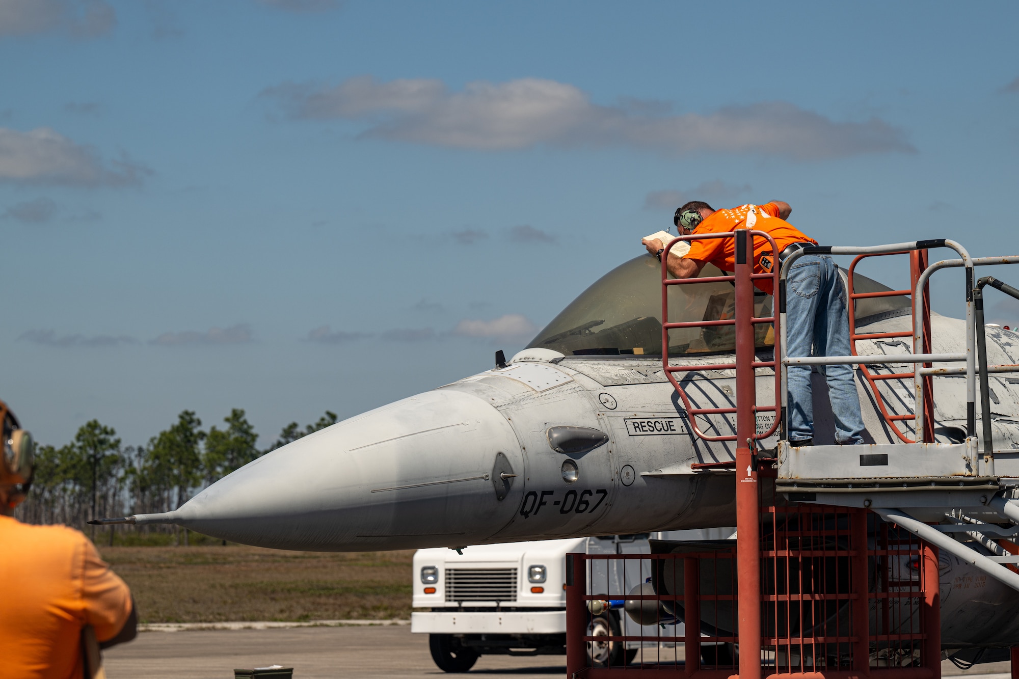 A contractor looks into the cockpit of an aircraft