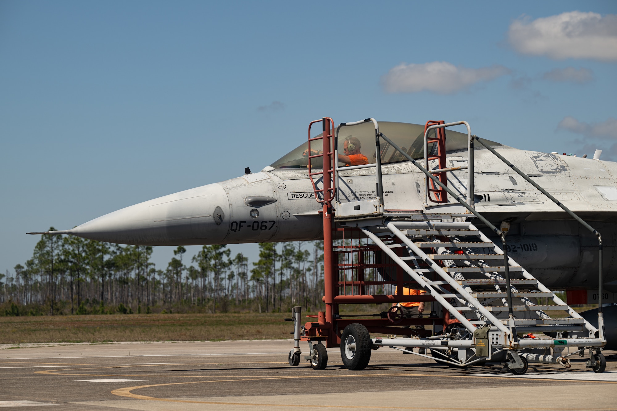 A contractor sits inside the cockpit of an aircraft while performing preflight checks