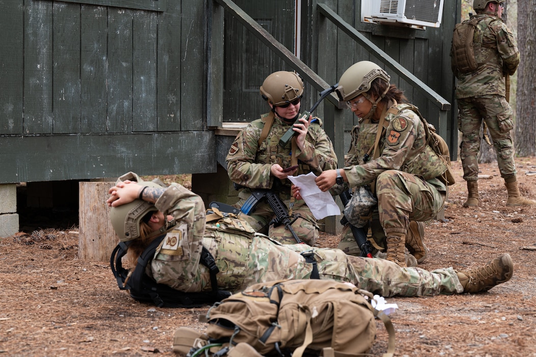 U.S. Air Force Capt. Laken Watson, left, 217th Training Squadron instructor, Master Sgt. Latrice Rybarczyk, right, 42nd Operational Medical Readiness Squadron senior enlisted leader, and Airman 1st Class Jessie Replogle, middle, 42nd Air Base Wing Command Post operation specialist, make a radio call out at the Vigilant Warrior training facility near Titus, Alabama, March 14, 2025.