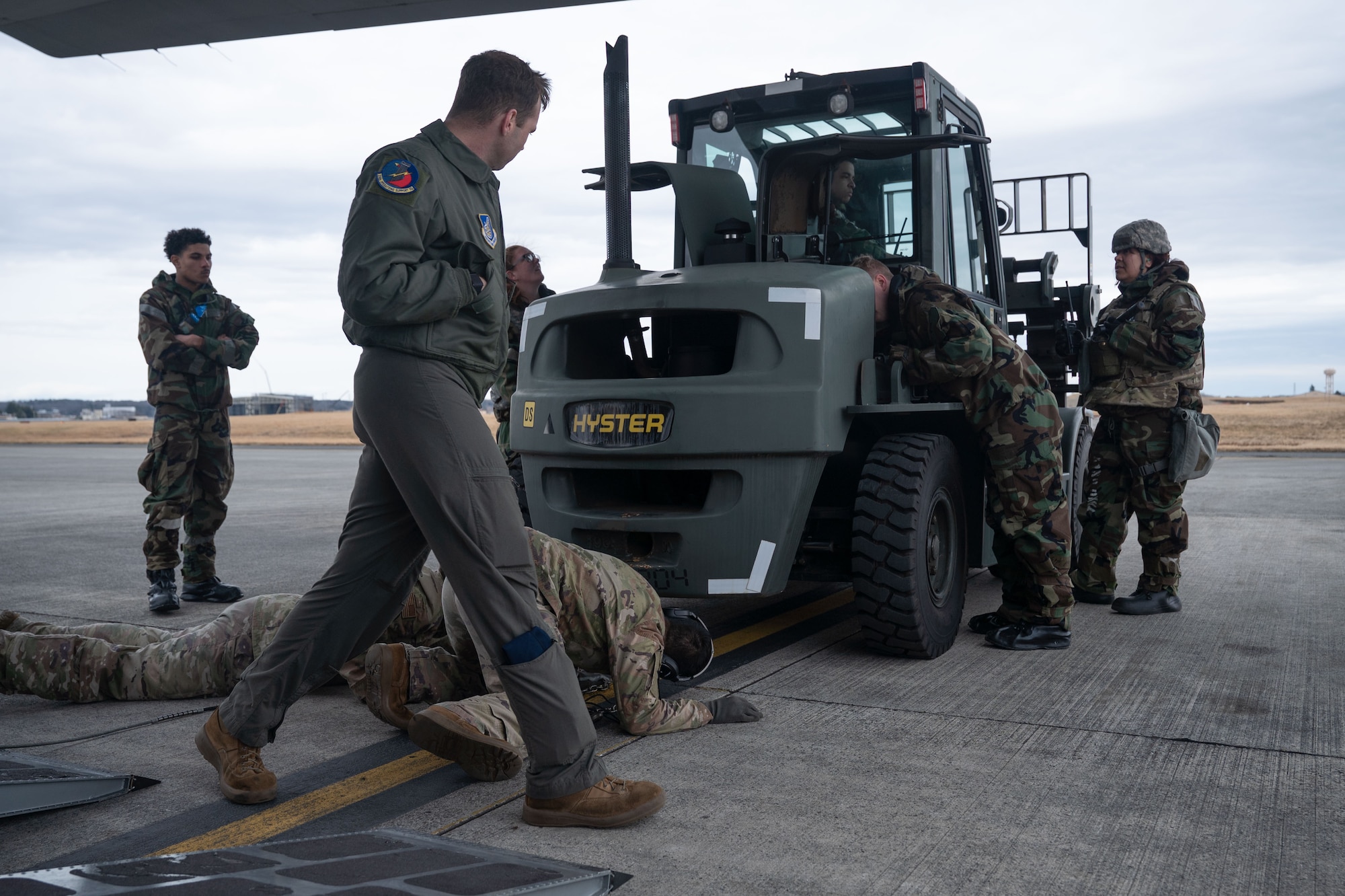 Airmen inspect a forklift.
