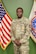 Male U.S. Army Soldier in uniform poses with American Flag and USAREC Flag behind him