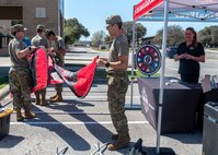 two service members folding a promotional flag