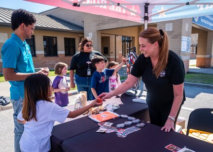 Lady gives basketball to young child.