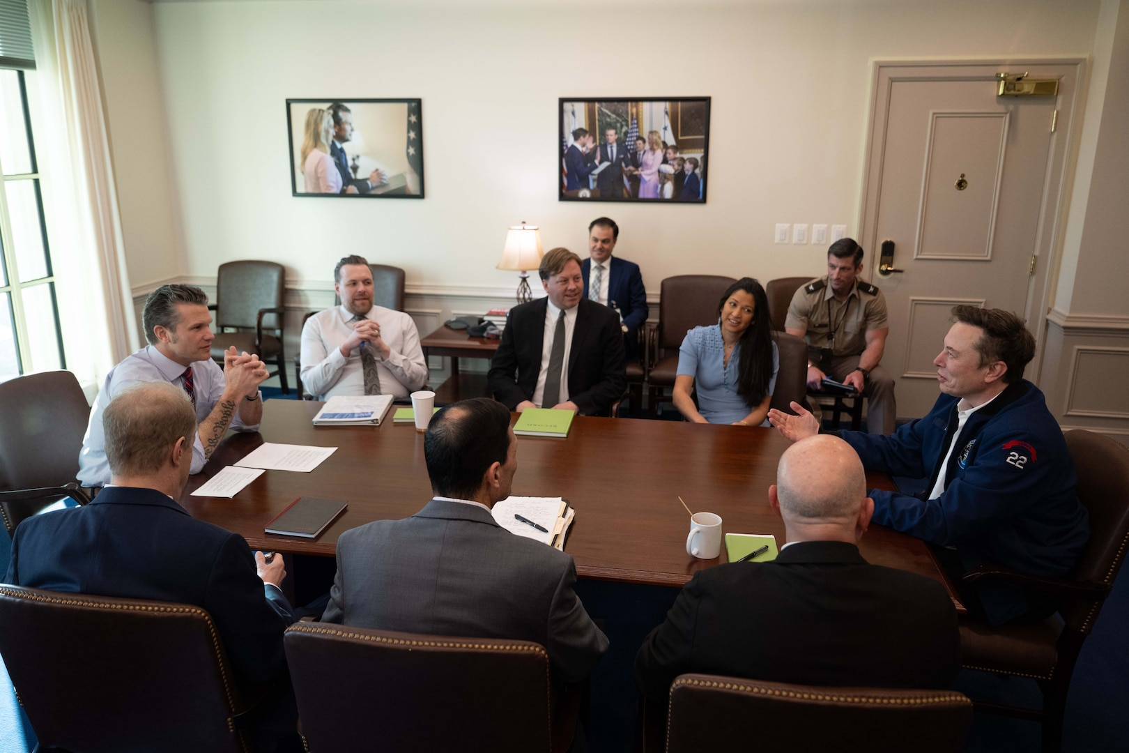 A group of people sit around a conference table in a well-lit room.