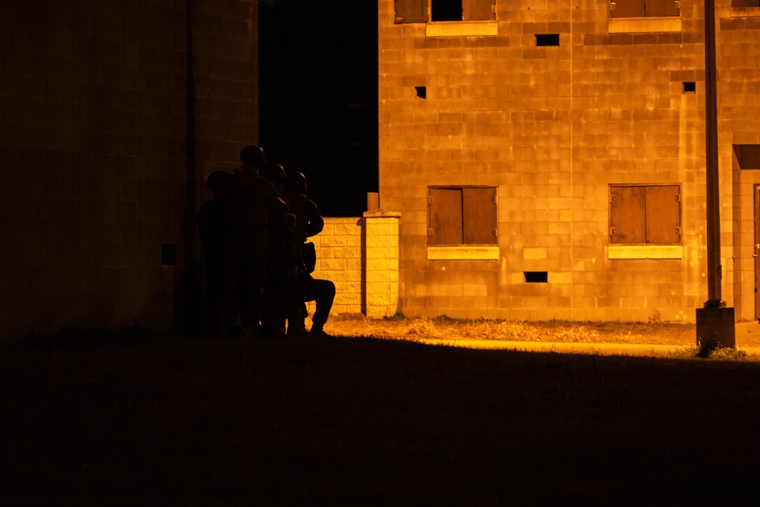 U.S. Marines with Marine Forces Reserve prepare to cross a street inside a simulated town during a field exercise on Camp Shelby Joint Forces Training Center, Mississippi, March 11, 2025. MARFORRES Marines conducted the exercise to maintain proficiency in warfighting, communication and leadership skills common to all Marines. (U.S. Marine Corps photo by Lance Cpl. Van Hoang)