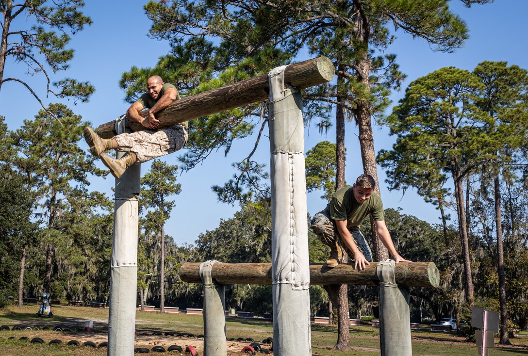 U.S. Marine Corps Staff Sgt. Alexander Sotoacevedo, network chief, left, and Sgt. Robert Hamlett, network administrator, both with Marine Aircraft Group 31, 2nd Marine Aircraft Wing, participate in the confidence course at Marine Corps Recruit Depot Parris Island, South Carolina, Oct. 25, 2024.  The confidence course is an obstacle course designed to build physical fitness, teamwork, and mental resilience among Marines.. (U.S. Marine Corps photo by Lance Cpl. Kayla LeClaire)