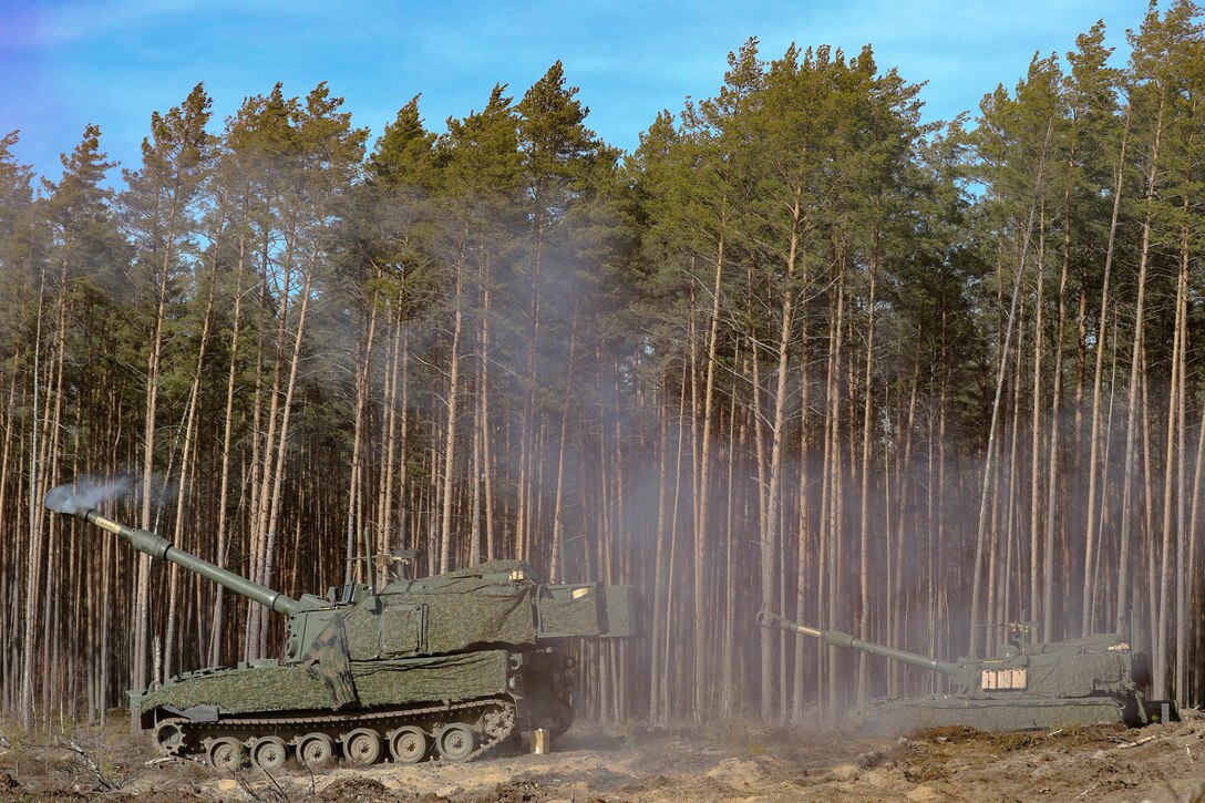 Two U.S. Army M109A7 Paladin self-propelled howitzer, (left) manned by Sgt. Achilles Gill, a section chief, Sgt. Carlo Enriquez, a gunner, Pfc. Nicolas Baker, a cannoneer, (right) Staff Sgt. Luis Torres, a section chief, Sgt. Roger Ellis, a gunner, Pvt. Dejuan Webley, a cannoneer with Charlie Battery, 1st Battalion, 41st Field Artillery Regiment, 41st Field Artillery Brigade produces smoke after firing an artillery shell during the Table VI live-fire certifications at Pabrade Training Area, Lithuania, Mar. 06, 2025. The German Armed Forces from the multinational battle group of  U.S. Army soldiers from the Charlie Battery, 1st Battalion, 41st Field Artillery Regiment supporting Task Force Iron. The shared training focused on the Artillery Systems Cooperation Activities (ASCA) program, as the 1-41st trained by sending digital fire missions from U.S. systems to German howitzers, while receiving digital fire missions from the German systems to the Paladins. Exercises like these ensure crews maintain lethal proficiency on the battlefield. V Corps participates in more than 50 exercises, symposiums, and leader summits annually with allied and partner nations to build capability and capacity along NATO’s eastern flank. (U.S. Army photo by Staff Sgt. Rose Di Trolio)