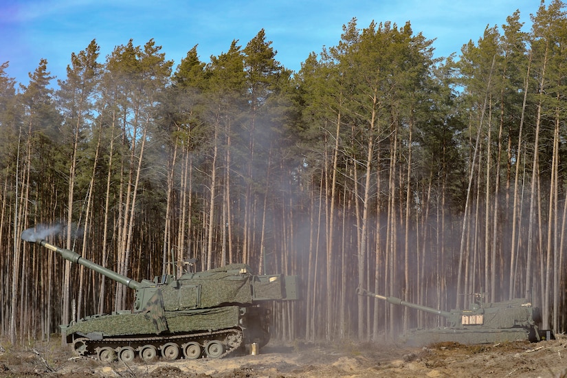 Two U.S. Army M109A7 Paladin self-propelled howitzer, (left) manned by Sgt. Achilles Gill, a section chief, Sgt. Carlo Enriquez, a gunner, Pfc. Nicolas Baker, a cannoneer, (right) Staff Sgt. Luis Torres, a section chief, Sgt. Roger Ellis, a gunner, Pvt. Dejuan Webley, a cannoneer with Charlie Battery, 1st Battalion, 41st Field Artillery Regiment, 41st Field Artillery Brigade produces smoke after firing an artillery shell during the Table VI live-fire certifications at Pabrade Training Area, Lithuania, Mar. 06, 2025. The German Armed Forces from the multinational battle group of  U.S. Army soldiers from the Charlie Battery, 1st Battalion, 41st Field Artillery Regiment supporting Task Force Iron. The shared training focused on the Artillery Systems Cooperation Activities (ASCA) program, as the 1-41st trained by sending digital fire missions from U.S. systems to German howitzers, while receiving digital fire missions from the German systems to the Paladins. Exercises like these ensure crews maintain lethal proficiency on the battlefield. V Corps participates in more than 50 exercises, symposiums, and leader summits annually with allied and partner nations to build capability and capacity along NATO’s eastern flank. (U.S. Army photo by Staff Sgt. Rose Di Trolio)