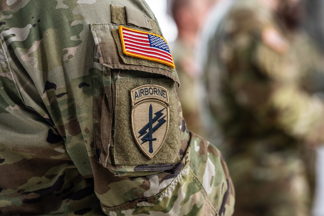 A closeup image of an Army airborne patch, two lightning bolts diagonally over a vertical sword. and a colored U.S. flag patch