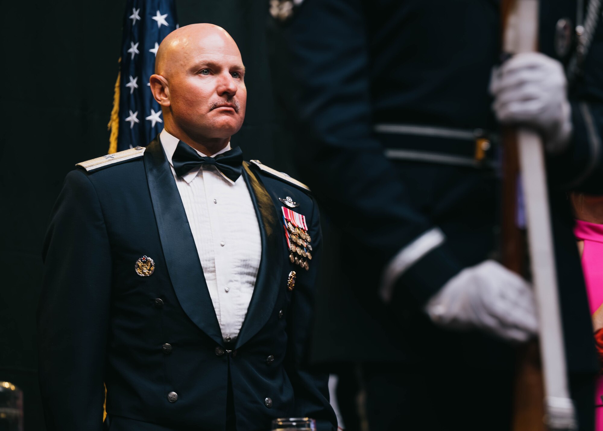 U.S. Air Force Brig. Gen. David Berkland, 56th Fighter Wing commander, stands at attention for the presentation of the colors during 56th FW 2025 Dining Out.