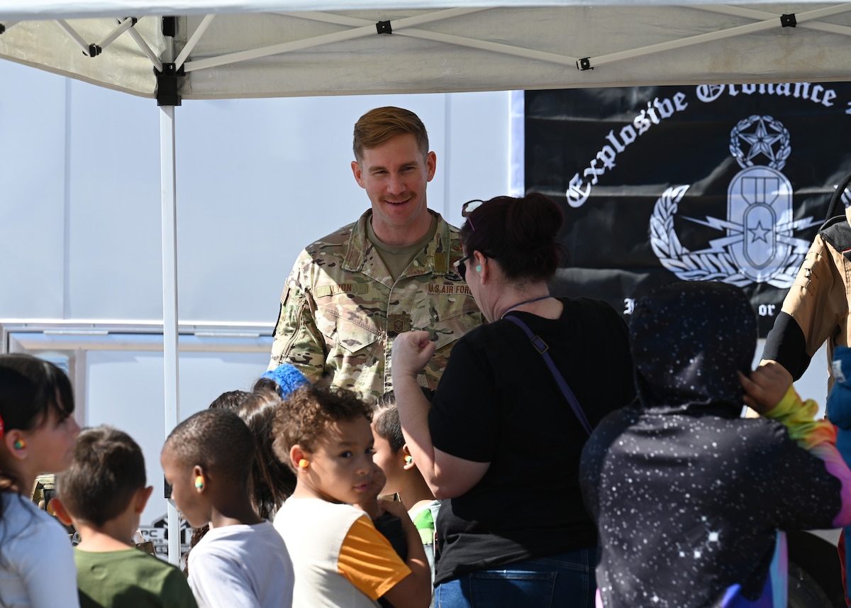 U.S. Air Force Master Sgt. Kyle Lyon, 355th Explosive Ordnance Disposal contingency instructor, interacts with students during the Thunder and Lightning Over Arizona Air Show at Davis-Monthan Air Force Base, Arizona, March 21, 2025. The biannual air show offered guests the opportunity to tour more than 40 static displays, explore science, technology, engineering, art and math activities, and watch 15 aerial performances. (U.S. Air Force photo by Staff Sgt. Abbey Rieves)