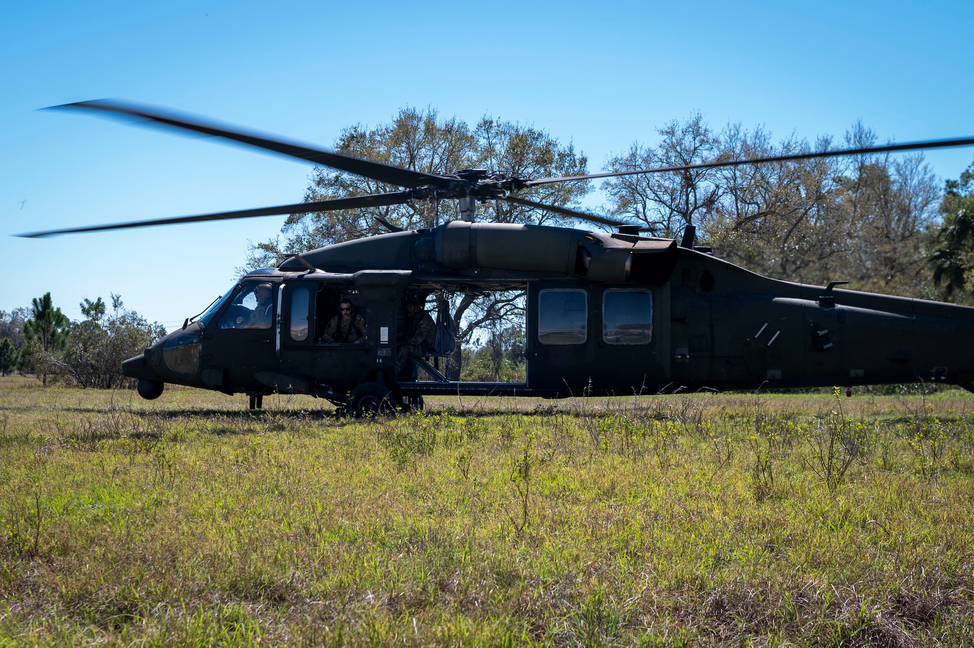 U.S. service members prepare to take off in a UH-60 Black Hawk at MacDill Air Force Base, Florida, March 7, 2025. The 6th Security Forces Squadron joined forces with Alpha Company, 5th Battalion, 159th Aviation Regiment in a new initiative, the Coastal Observation Aerial Security Team, to survey MacDill’s coastline by air. The partnership strengthens waterway security and ensures the installation’s critical assets remain protected from potential threats. (U.S. Air Force photo by Airman 1st Class Alicia Campbell)