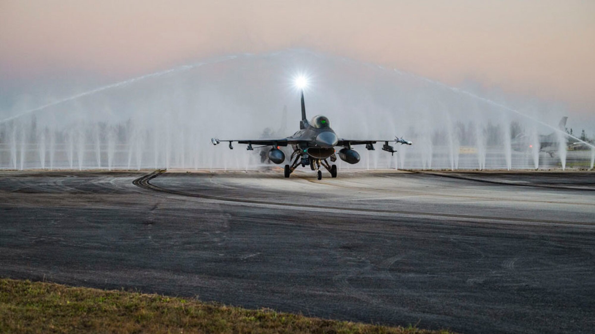 A U.S. Air Force F-16 Fighting Falcon runs through a bird bath for a jet wash after a Large Force Exercise at Homestead Air Reserve Base, Florida, March 11, 2025. The LFE provided invaluable exposure to new environments and equipment, enabling Airmen to adapt quickly and efficiently, enhancing their ability to deploy, operate, and troubleshoot in dynamic and ever-changing conditions. (U.S. Air Force photo by Senior Airman Michelle Ferrari)