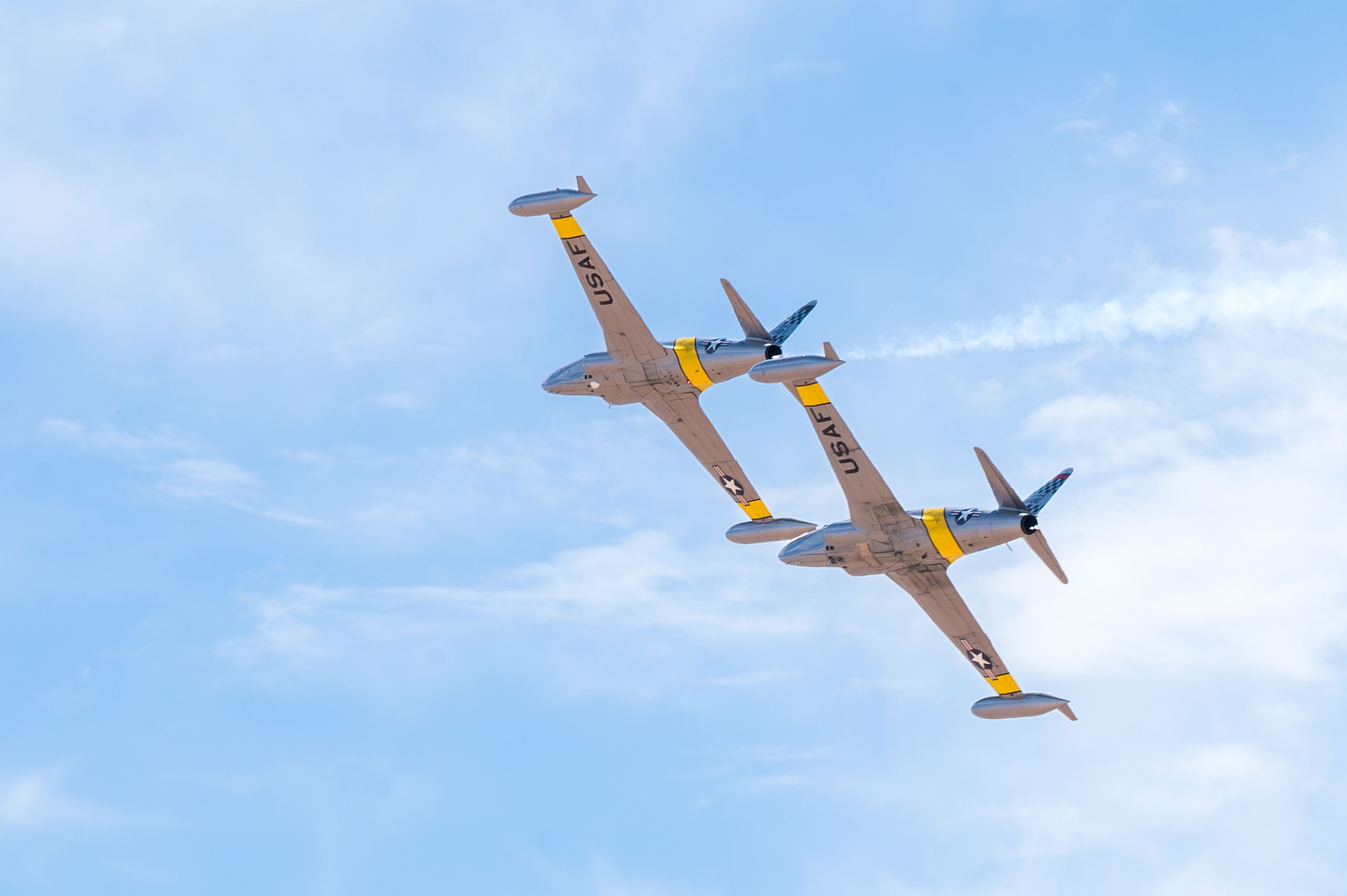 Two U.S. Air Force T-33 Shooting Star aircraft perform an aerial demonstration at the Thunder and Lightning Over Arizona Air Show at Davis-Monthan Air Force Base, Arizona, March 23, 2025. The show included a number of acrobatic maneuvers that highlighted the capabilities of the T-33. (U.S. Air Force photo by Senior Airman Jasmyne Bridgers-Matos)